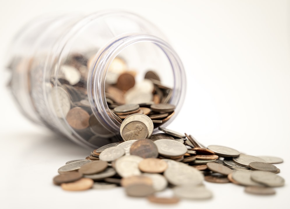 Coins spilling out of a glass jar