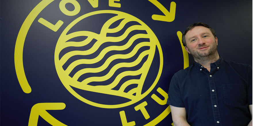 Lecturer stood in front of Leeds Trinity University sign