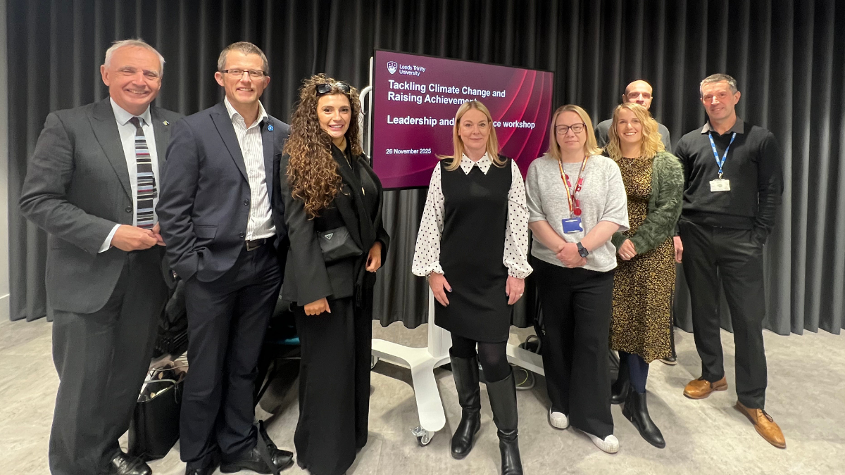 A group of climate change education experts lined up in front of a screen that reads Tackling climate change, raising achievement, the title of a conference they had just spoken at.