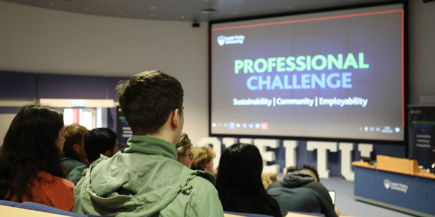 Back of students sat in lecture theatre with screen reading Professional Challenge