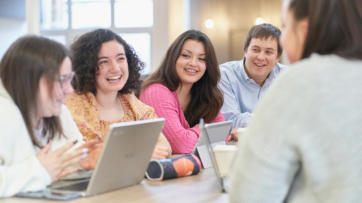 Students with laptops discussing work