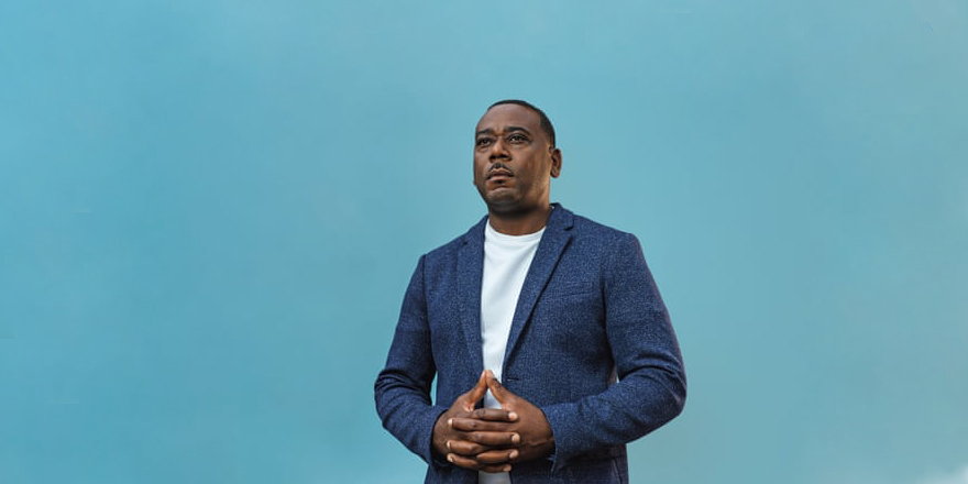 Man standing on stage with hands crossed