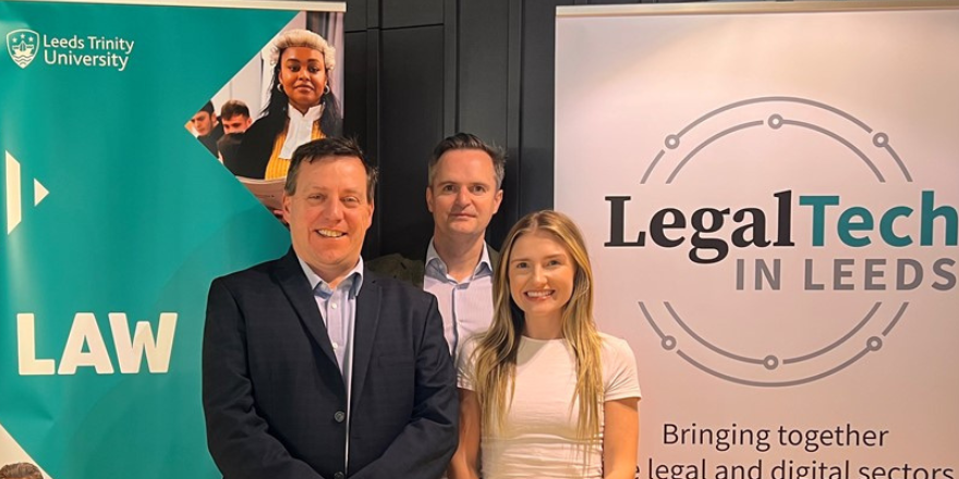 three people, one woman and two men, smiling celebrating law partnership to help others
