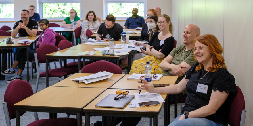 Teachers smiling and laughing sat around a table.