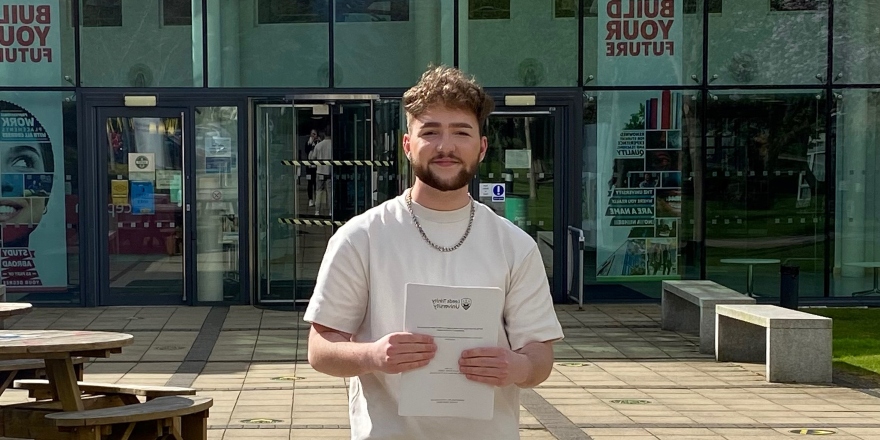 Brunette male in white t-shirt holds white paper