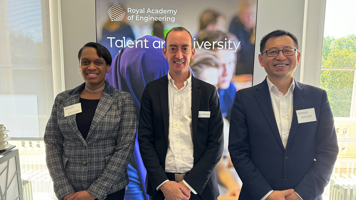 Three academics posing in front of a banner for the Royal Academy of Engineering.