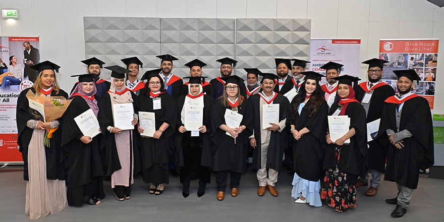 A group of students in caps and gowns holding their degrees.